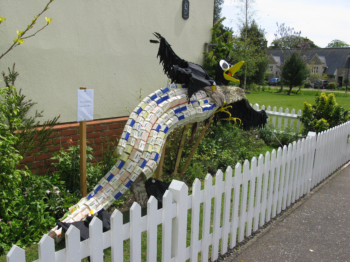 Handmade scarecrow of a crocodile eating crow
